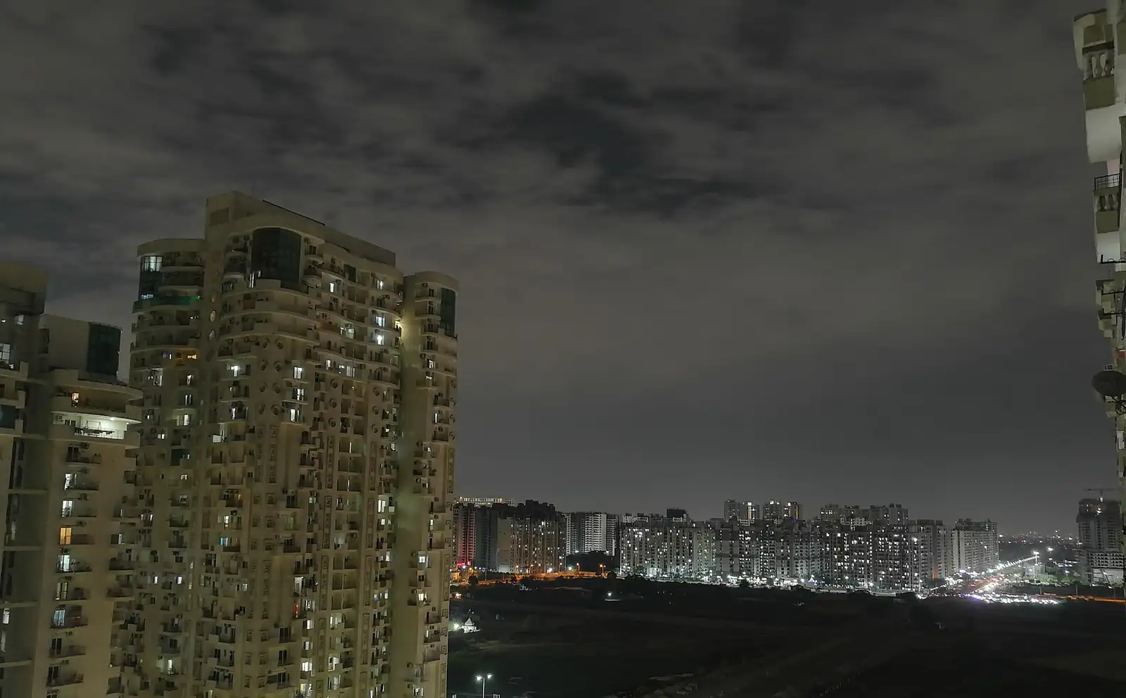 High-rise towers around Noida Sectors 76 to 78 at night